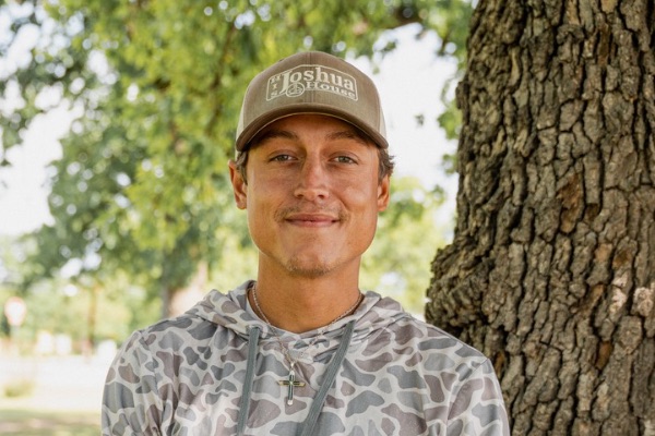 Colt standing in front of a tree at ARK of Highland Lakes offices